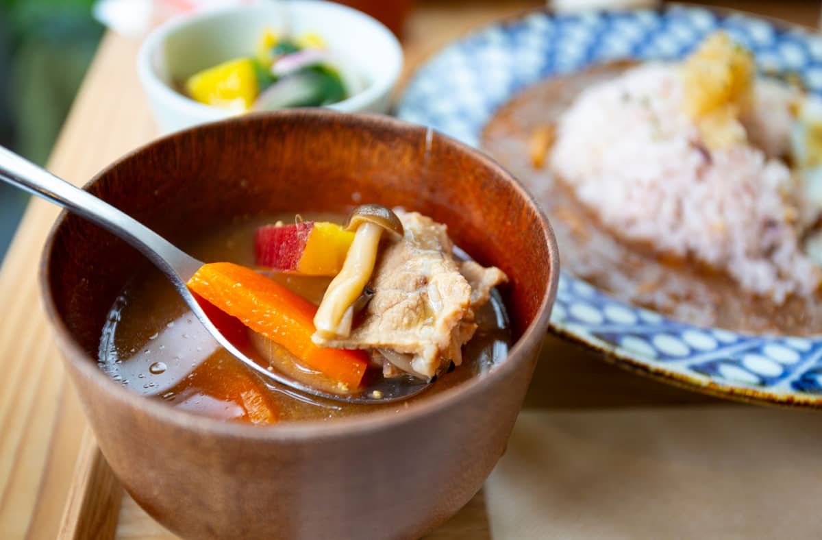 Japanese teishoku meal with rice, miso soup, pickles, and main dish on a wooden table, showing affordable authentic dining in Tokyo.