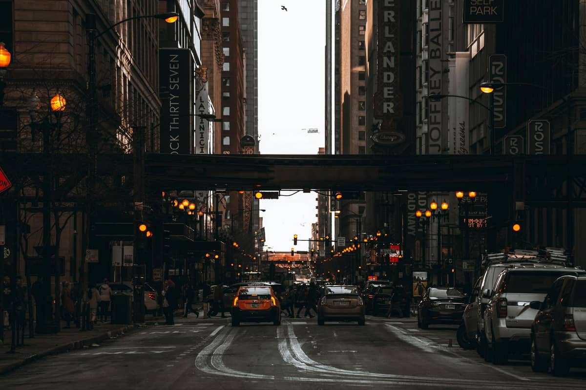 Vivace scena di strada nel centro di Chicago con auto, persone, edifici alti e insegne di ristoranti e teatri lungo la strada.
