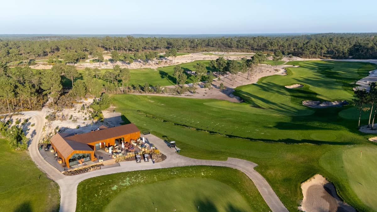 Aerial view of a luxury golf course surrounded by pine trees with a modern clubhouse, capturing Belek’s greenery and upscale ambiance.