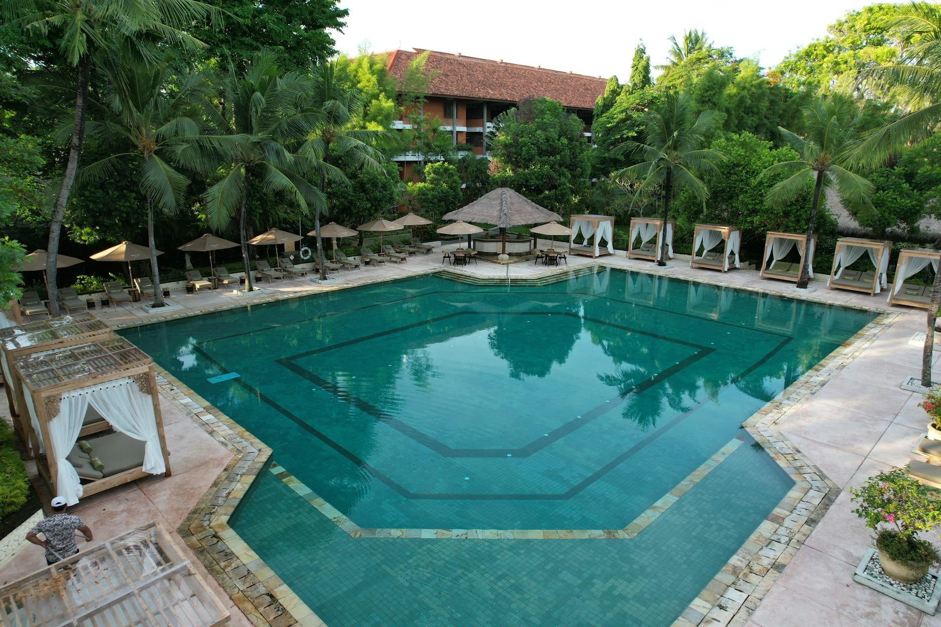 Pool eines Luxusresorts umgeben von Palmen in Nusa Dua auf Bali