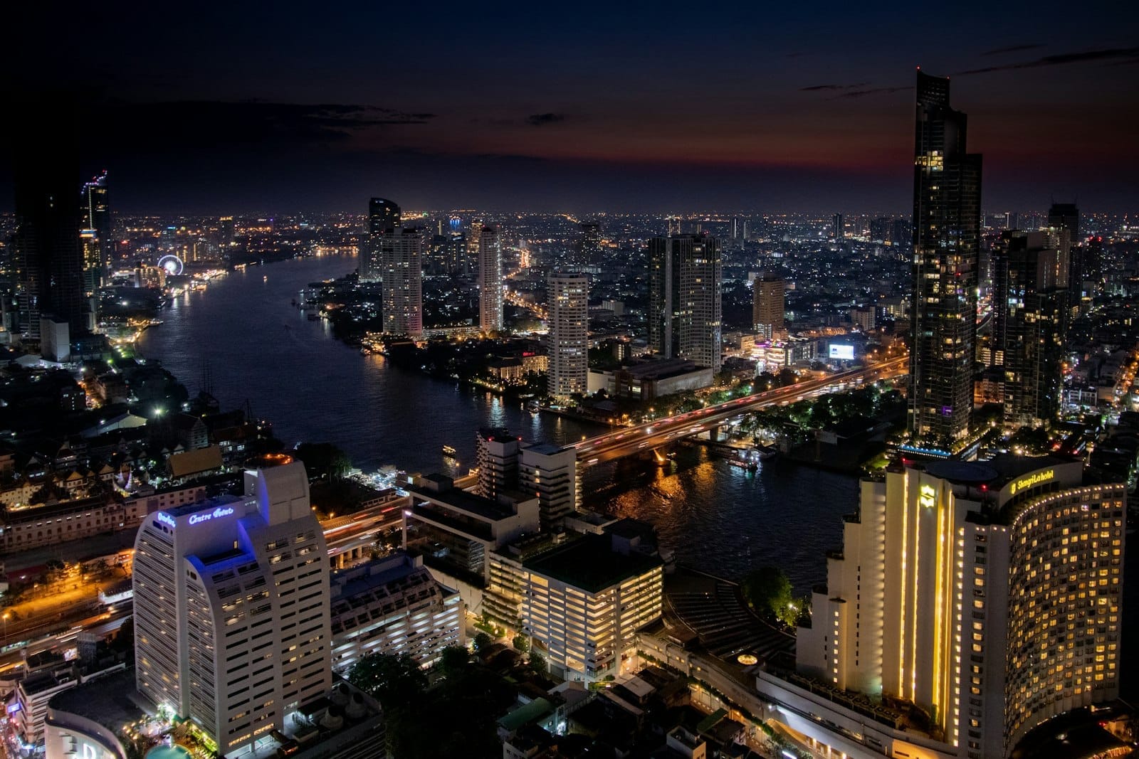 Skyline de Bangkok à noite com o rio Chao Phraya e distritos iluminados da cidade