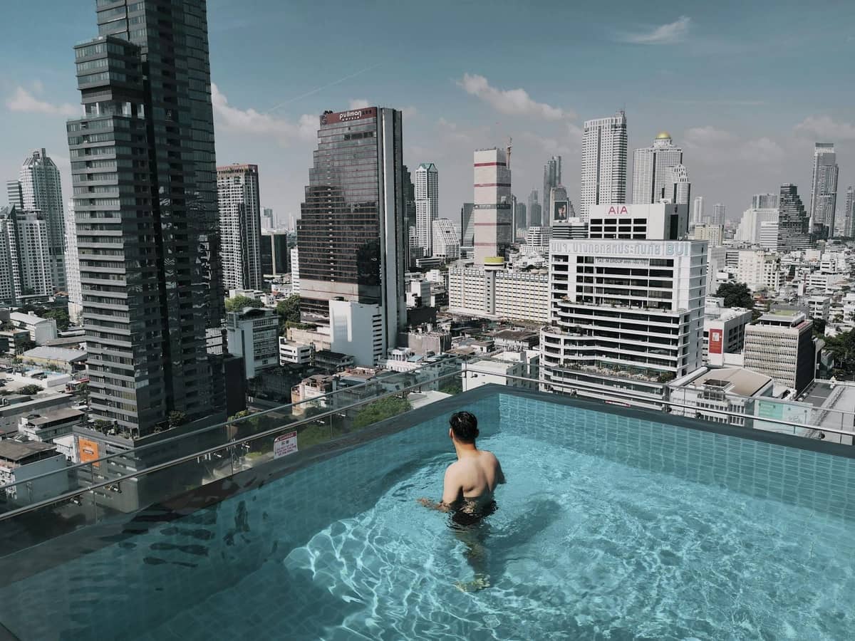 Piscina infinita em cobertura com vista para o horizonte de Bangkok, típico hotel nos distritos centrais.