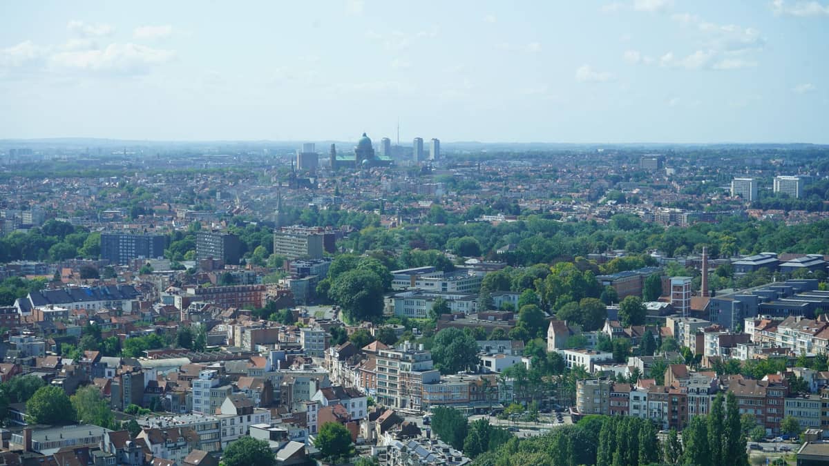 Ampla vista aérea do centro de Bruxelas com vários bairros, espaços verdes e marcos da cidade em um dia claro.