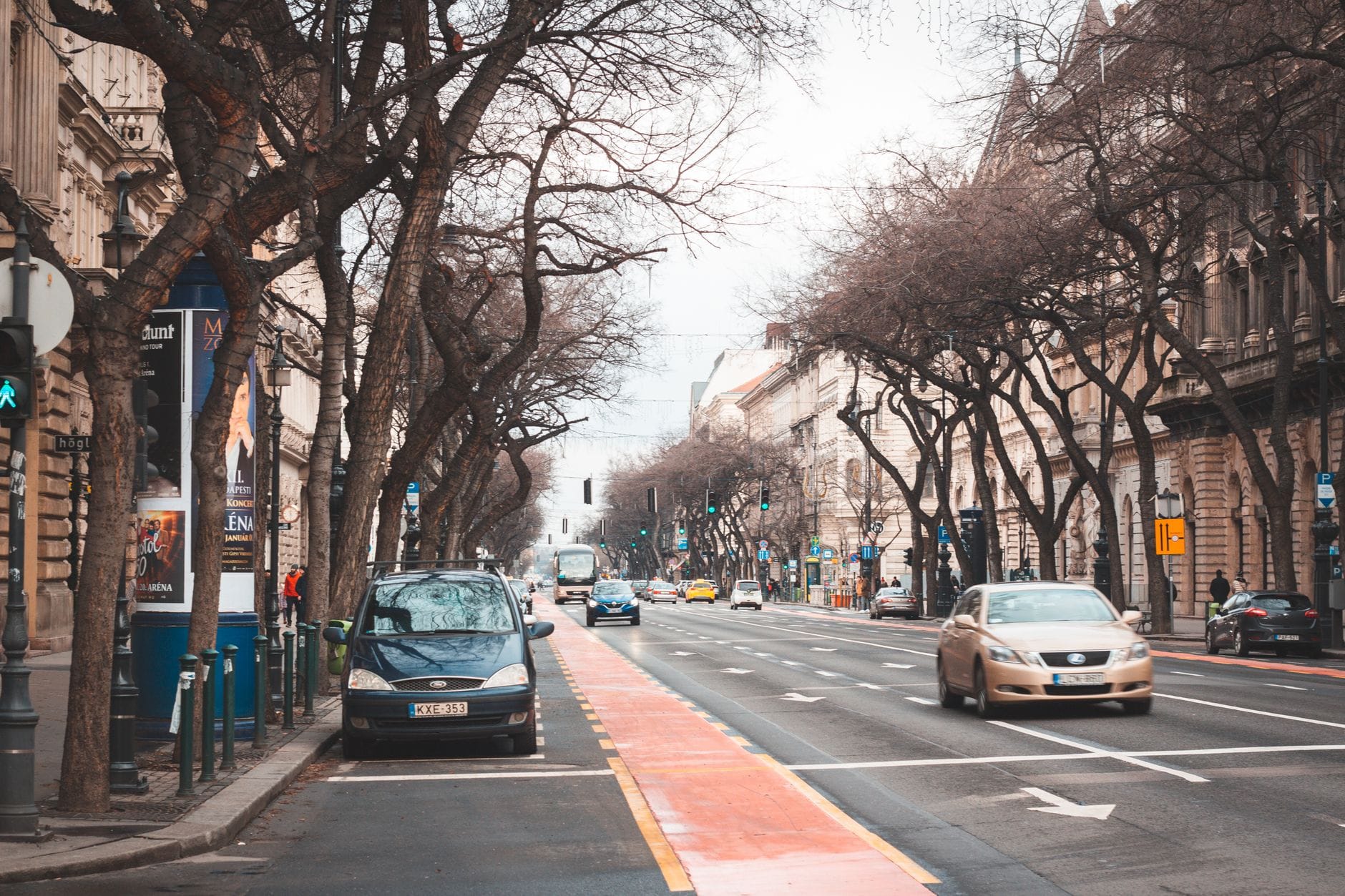 Blick entlang der Andrássy Avenue in Budapest mit klassischen Gebäuden aus dem 19. Jahrhundert, baumgesäumten Gehwegen und Verkehr, der Eleganz und urbanen Stil zeigt.