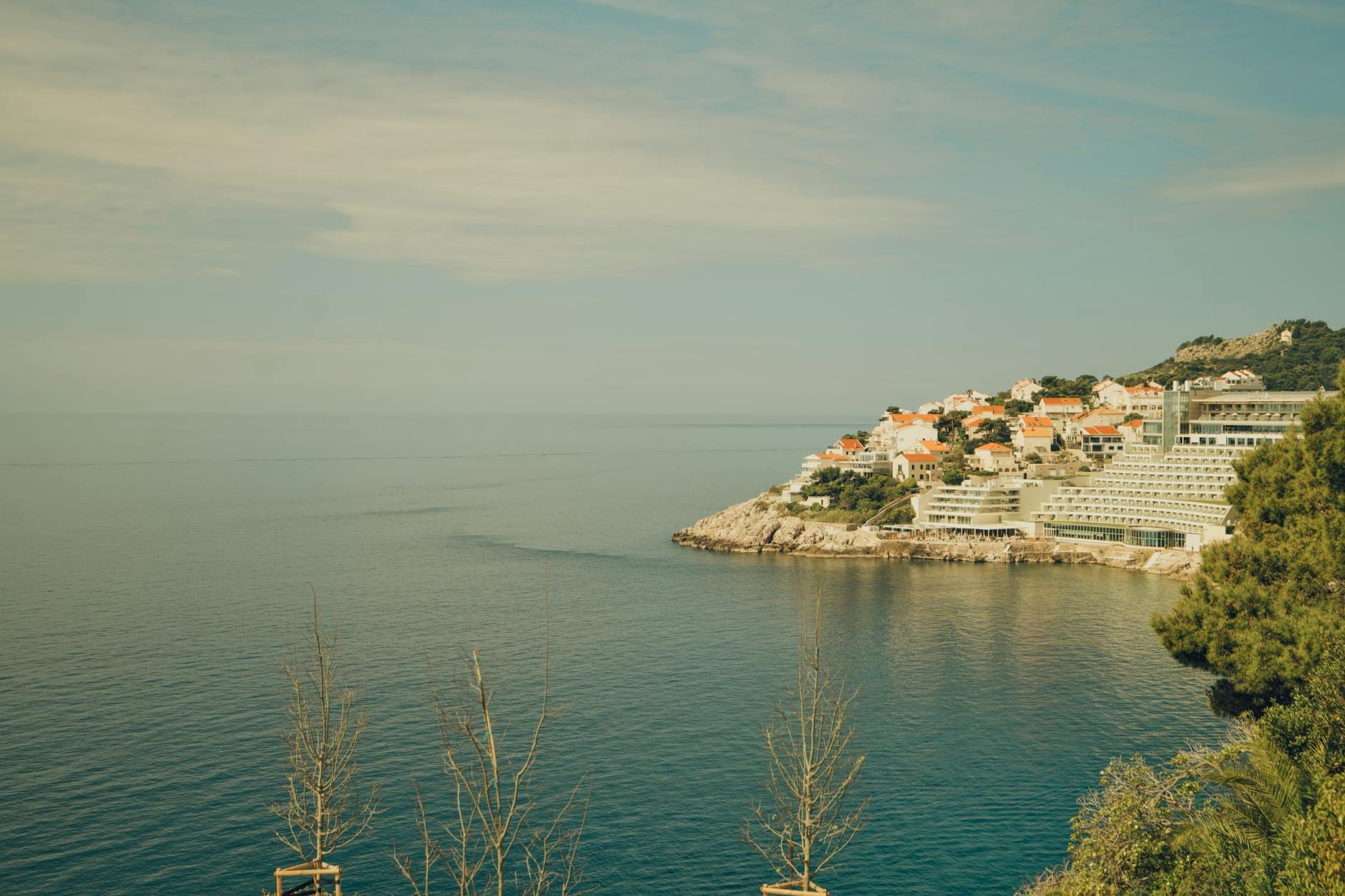 Vista del área de Ploče en Dubrovnik con hoteles y villas agrupados en la costa del Adriático, vista desde el agua en un día soleado.