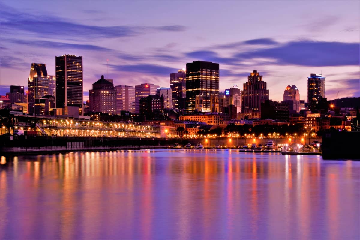 Montreals Skyline bei Sonnenuntergang: Die Wolkenkratzer der Innenstadt spiegeln sich im Wasser – ein Überblick über die wichtigsten Viertel für Besucher.
