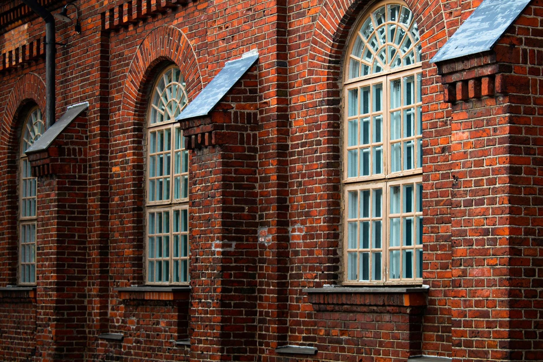 Edificio histórico de ladrillo con altas ventanas arqueadas y mampostería detallada, que representa la arquitectura del siglo XIX de Germantown en Nashville.