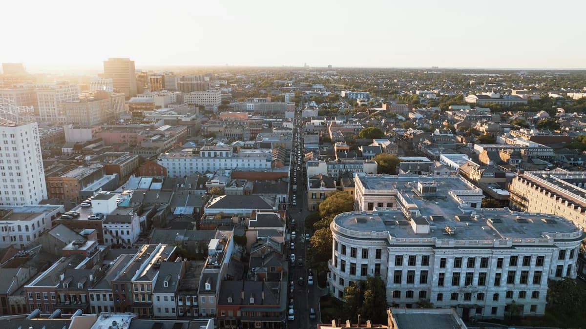 Aerial view of New Orleans showing a mix of historic buildings and neighborhood blocks at sunset.