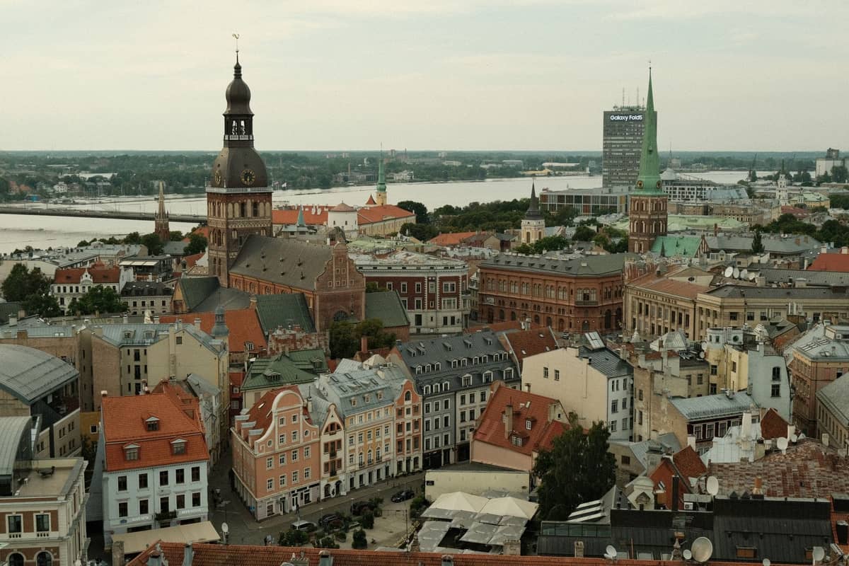 Luftaufnahme der Altstadt von Riga mit historischen Gebäuden, roten Dächern und der markanten Kuppel des Riga Doms nahe der Daugava.