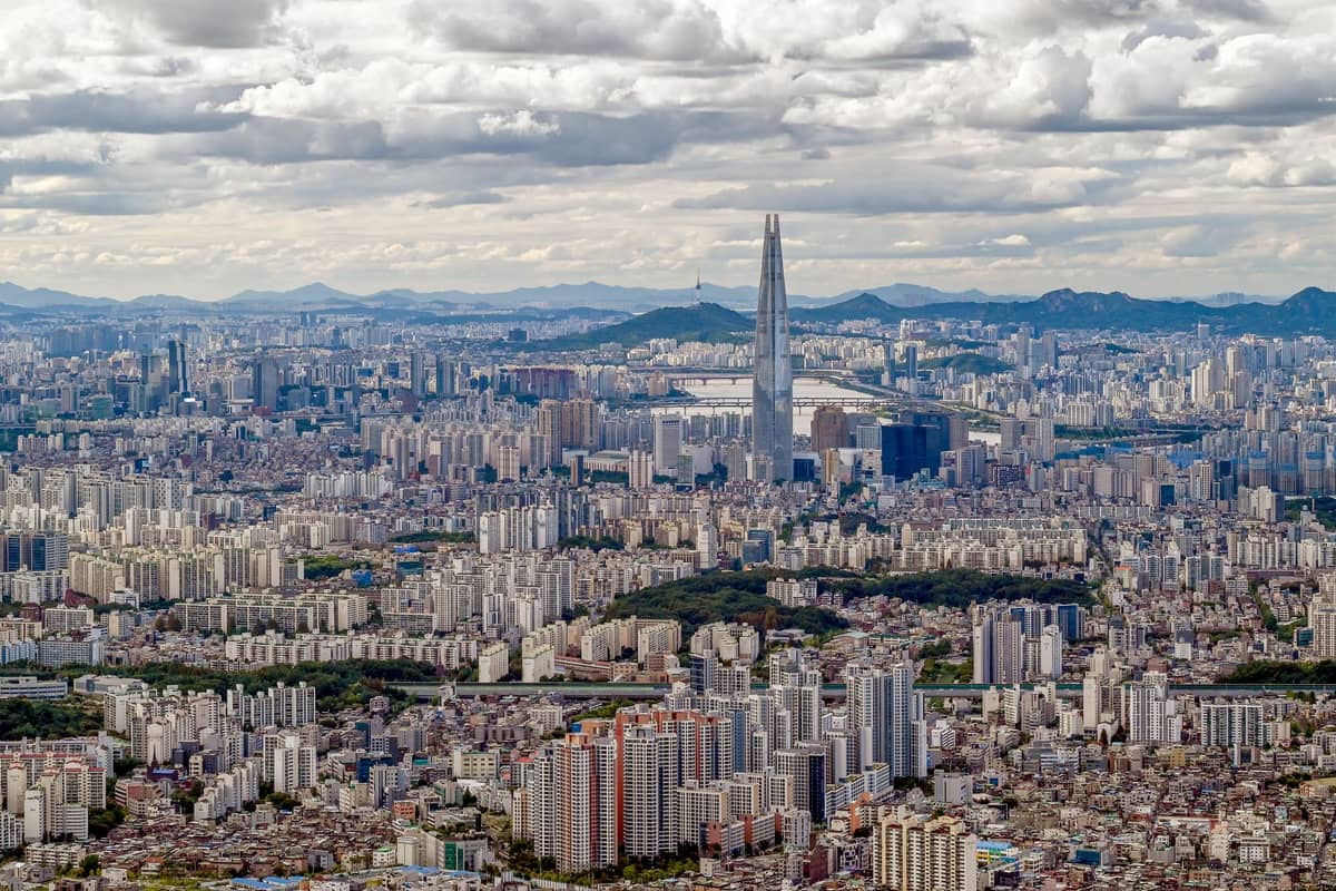 Vista panorâmica de Seul com foco na Lotte World Tower em Jamsil, rodeada por arranha-céus densos e paisagem urbana