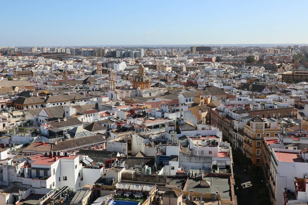 วิวทางอากาศแบบพาโนรามาเหนือหลังคาของเมือง Seville แสดงให้เห็นย่านเมืองที่หนาแน่นภายใต้ท้องฟ้าใส