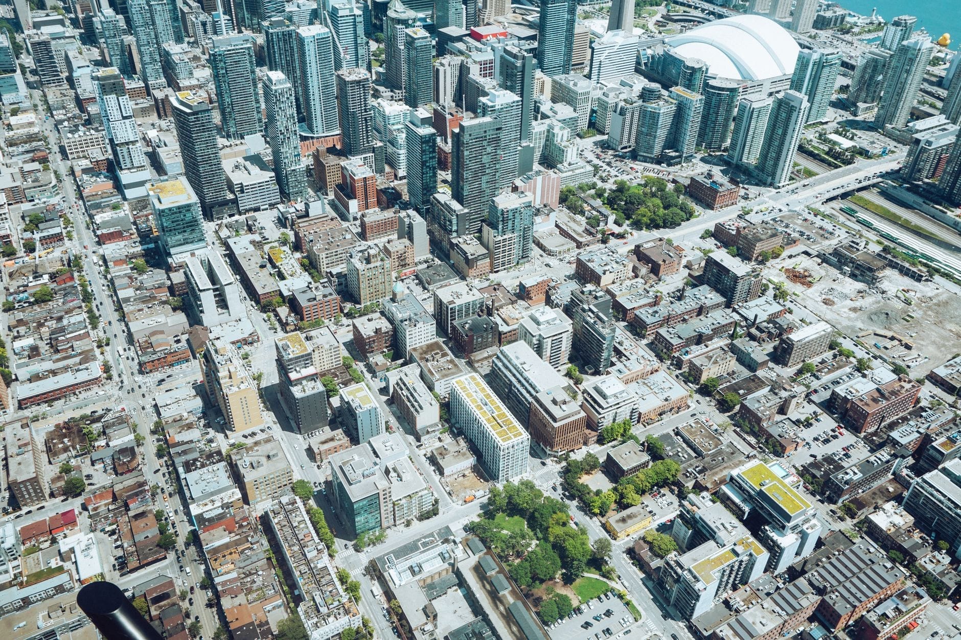 Vista aérea do centro de Toronto mostrando quarteirões distintos e edifícios principais, incluindo o Rogers Centre e os arranha-céus próximos.