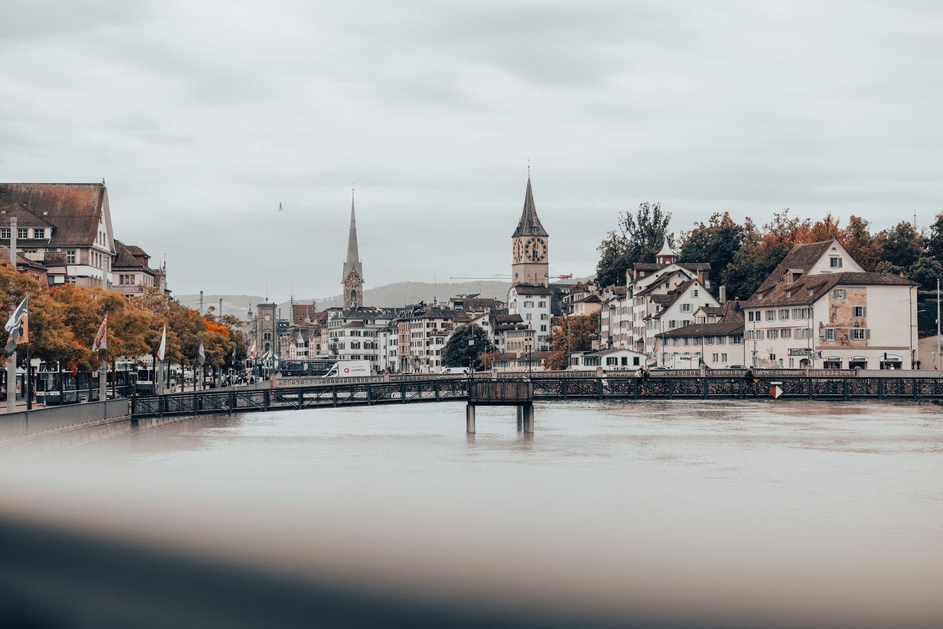 วิวกว้างกลางเมืองซูริก เห็นแม่น้ำ Limmat ตึกรามแบบประวัติศาสตร์ และยอดโบสถ์สำคัญอย่าง St. Peter’s กับ Fraumünster ใต้ท้องฟ้าครึ้ม