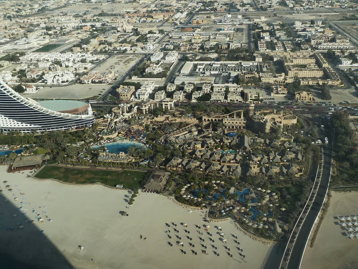 Luftaufnahme des Wild Wadi Waterparks in Dubai mit Pools, Wasserrutschen, üppigem Grün und dem angrenzenden Hotel am Jumeirah Beach.