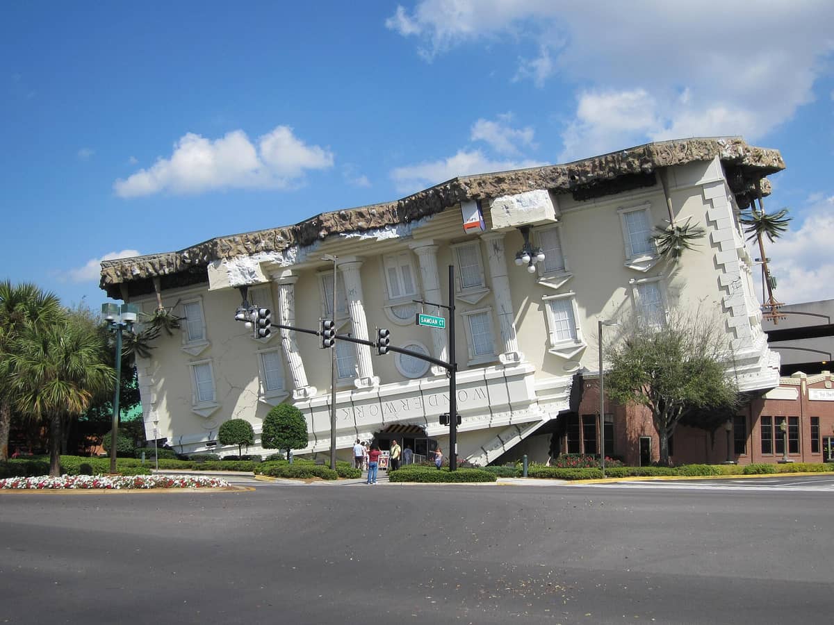 WonderWorks Orlando building seen from across the street, featuring its iconic upside-down architecture on a sunny day with blue sky.