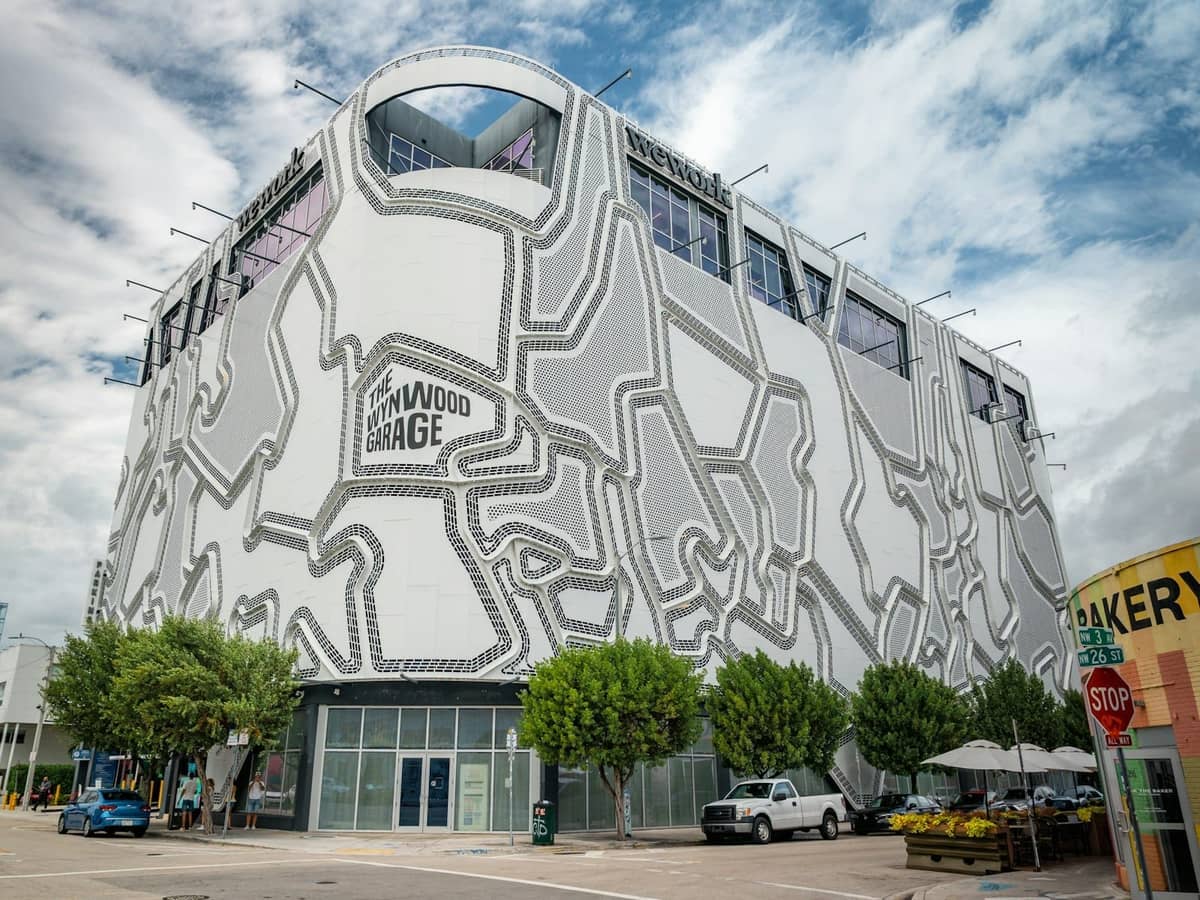 Wynwood Garage building with distinctive geometric facade next to trees and city street in Miami