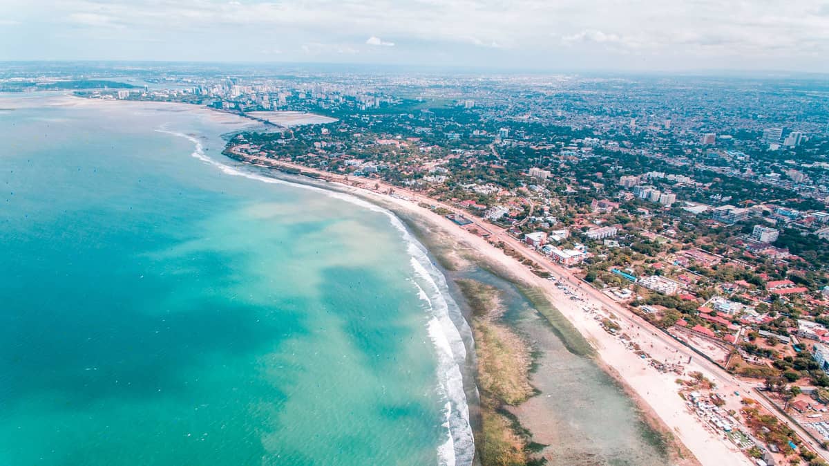Widok z lotu ptaka na wybrzeże z turkusową wodą i panoramą Dar es Salaam w Tanzanii – tam, gdzie miejskie życie spotyka się z brzegiem Oceanu Indyjskiego.