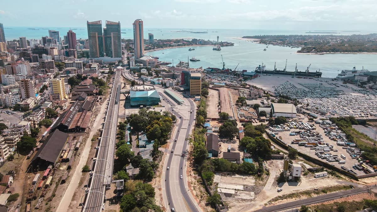Vista aérea de la ciudad de Dar es Salaam con edificios modernos, puerto y zona costera bajo un cielo despejado