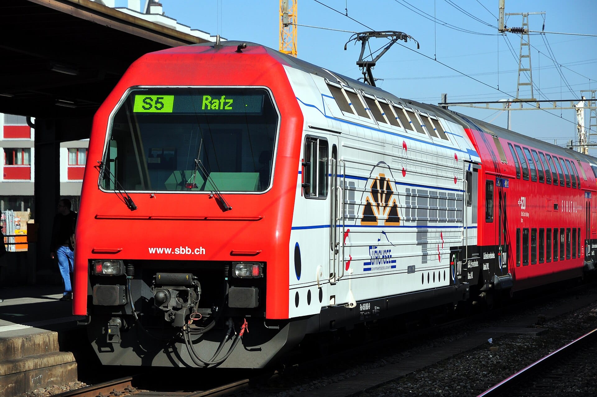 รถไฟ S-Bahn สวิสพร้อมป้ายแสดงจุดหมาย 'S5 Rafz' บนชานชาลาสถานี ซึ่งเป็นเอกลักษณ์ของระบบขนส่งสาธารณะของซูริก