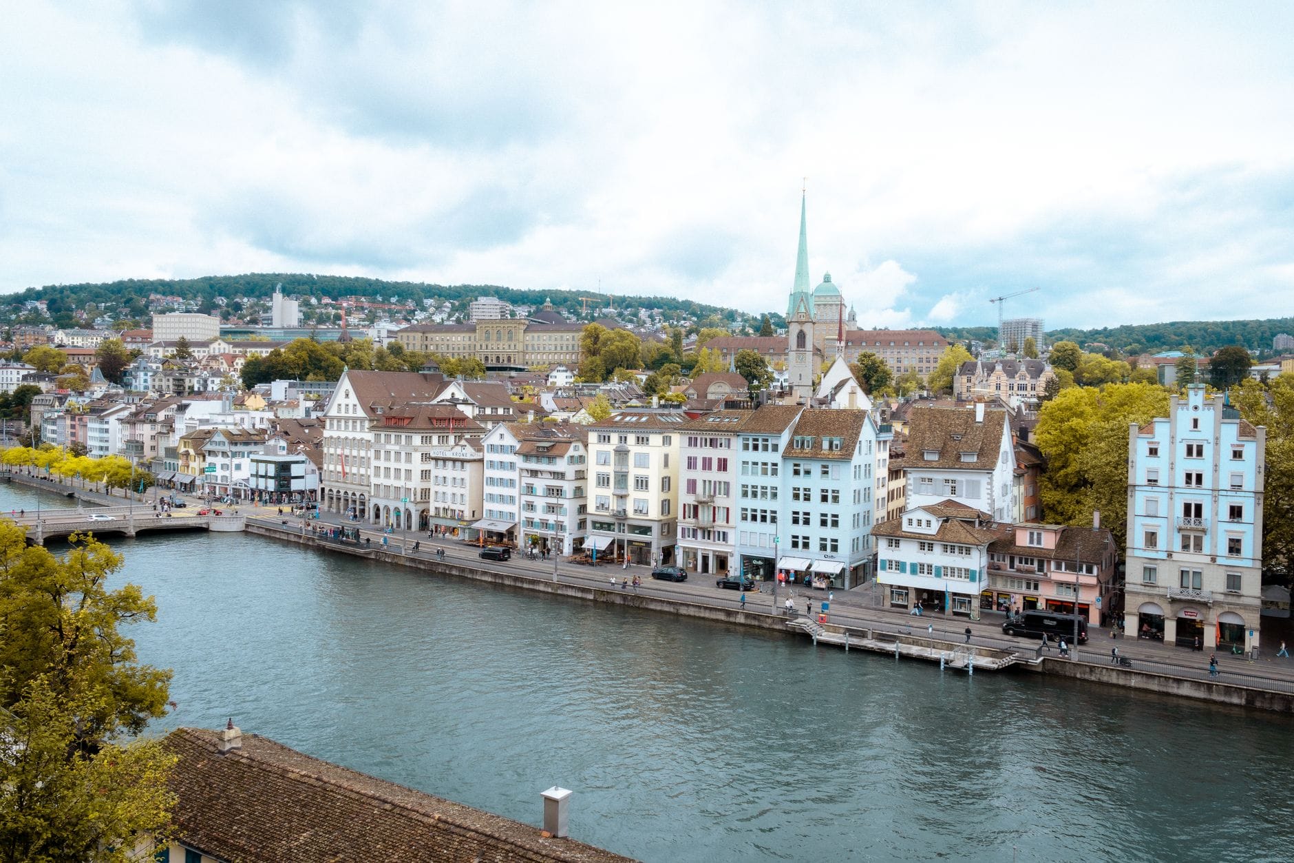 วิวกว้างของเมืองเก่า Zurich พร้อมอาคารสีสันสดใส แม่น้ำ และยอดโบสถ์ในวันที่มีเมฆมาก